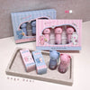 Gege bear lip balm set with packaging on a gray surface