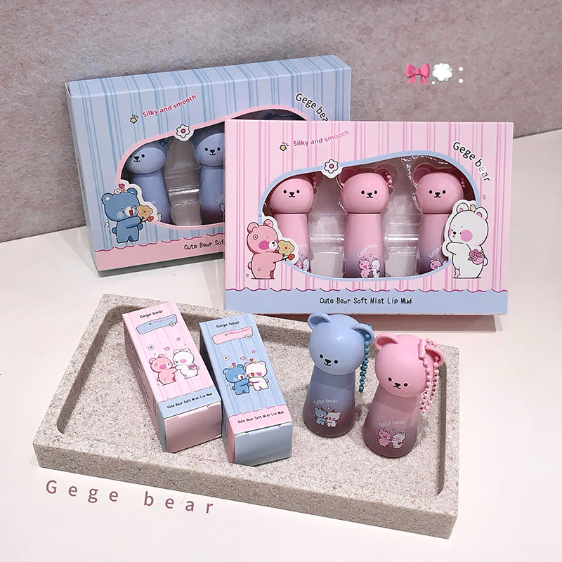 Gege bear lip balm set with packaging on a gray surface