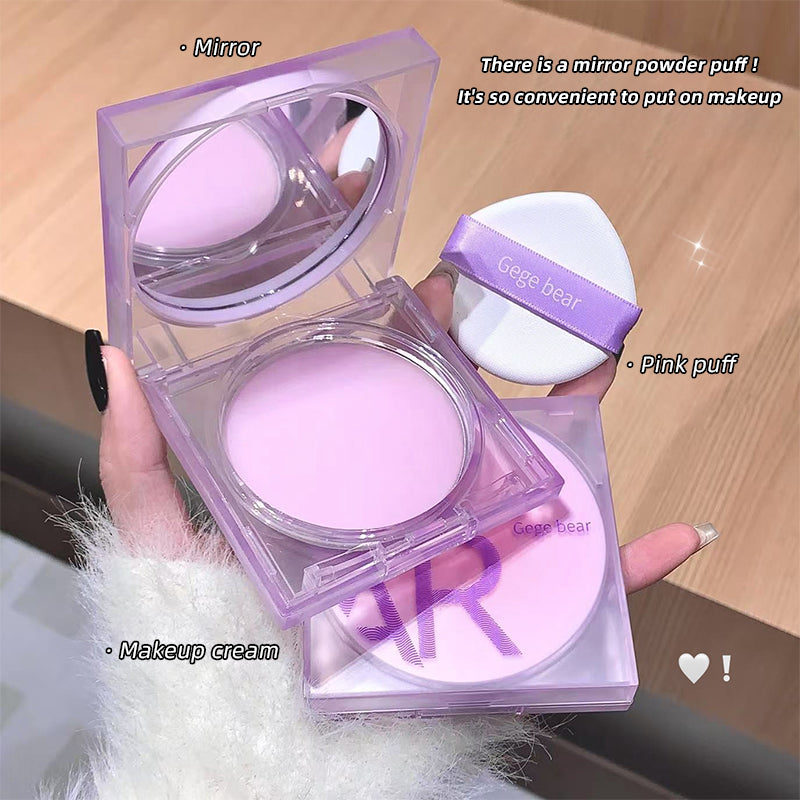 Purple makeup set with mirror, pink puff, and makeup cream on a wooden surface.