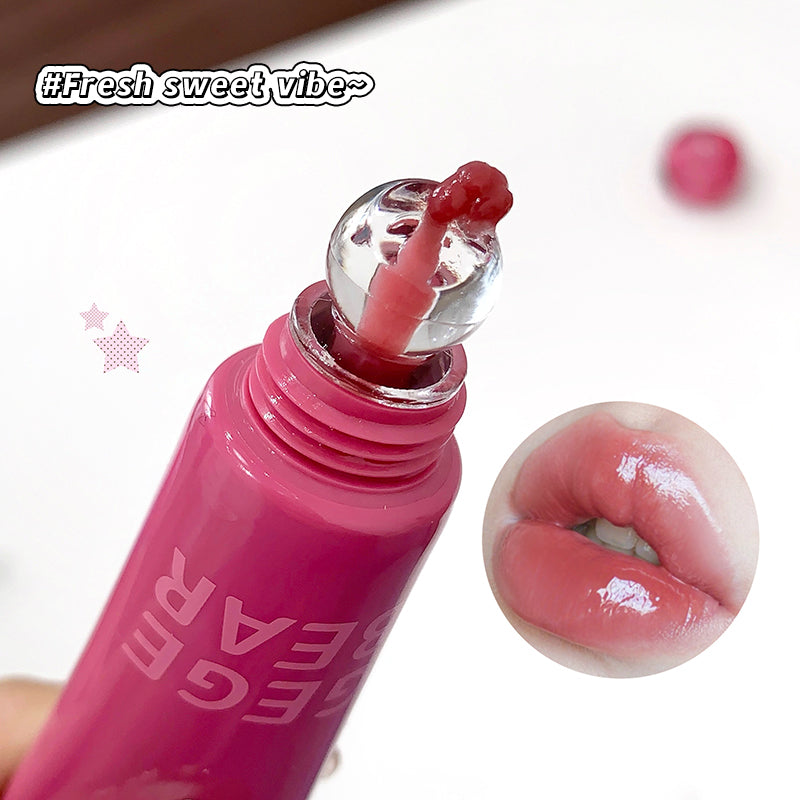 Pink lip gloss with applicator and close-up of lips wearing the product, branded 'GEE'AR.
