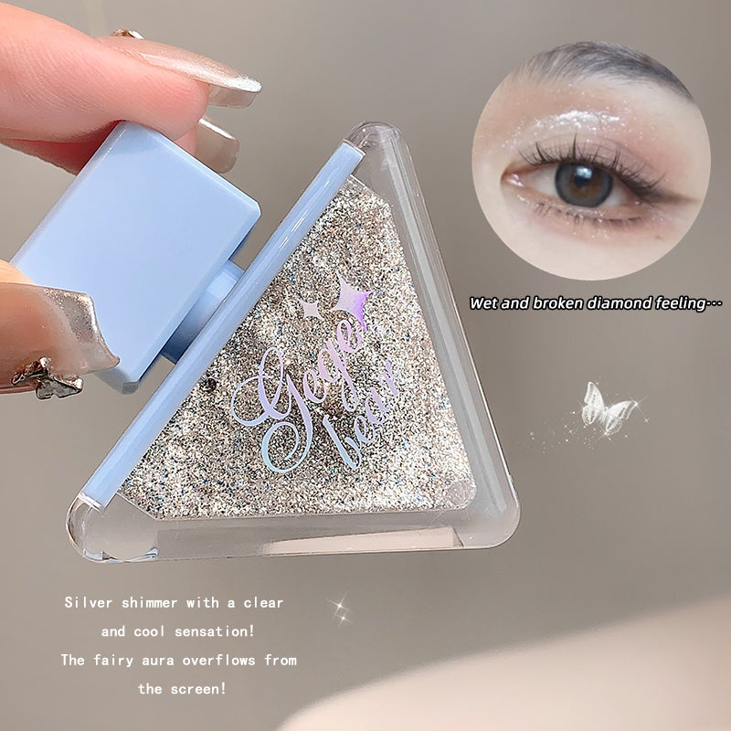 Triangle-shaped product with glittery texture and 'Gosh' branding, held by a hand.