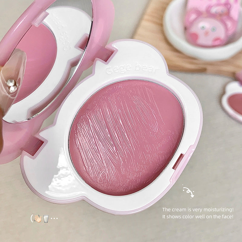 Pink blush compact with a white lid on a neutral background