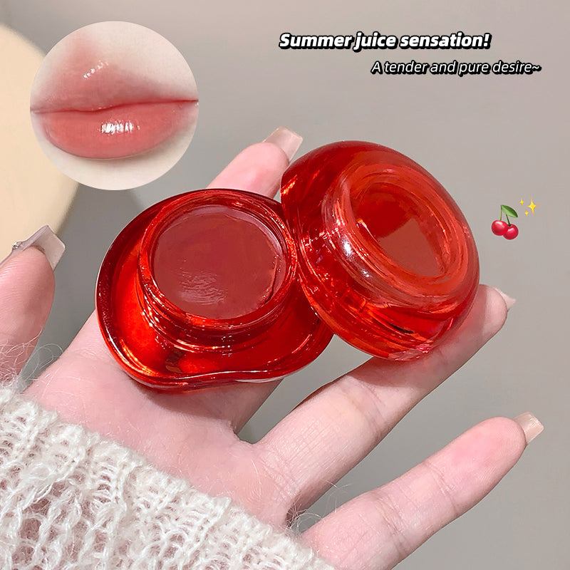 Red lip balm container held in a hand with a close-up of glossy lips and text 'Summer juice sensation!' on a gray background.