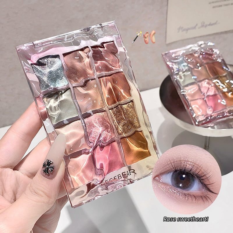 Makeup palette with colorful shades held by a hand, close-up of eye with glittery effect.