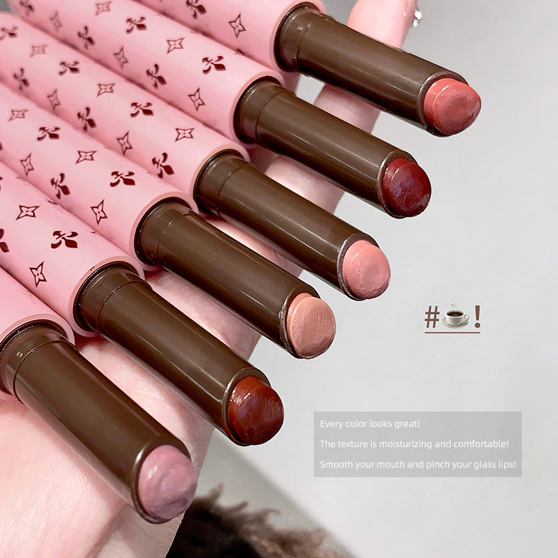 Set of pink and brown lipsticks with decorative design on a neutral background