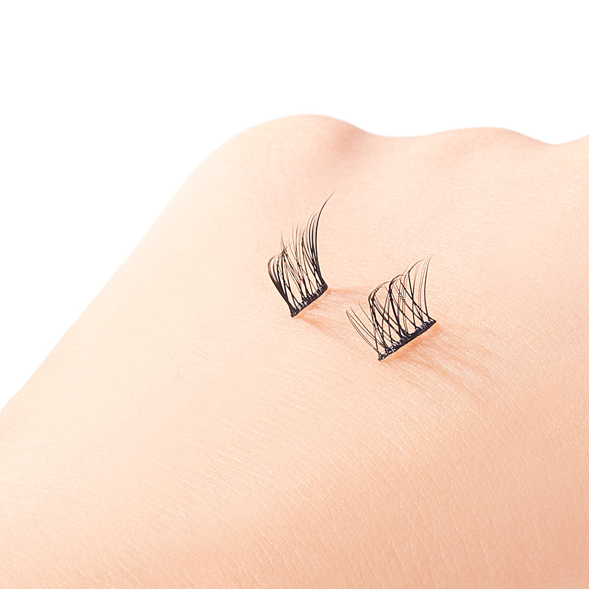 False eyelashes on a person's eyelid against a white background