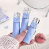 Three blue lip glosses with silver bows held by a hand, with a close-up of lips wearing one of them.