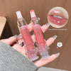 Two lip glosses held in a hand with a close-up of lips wearing the product.