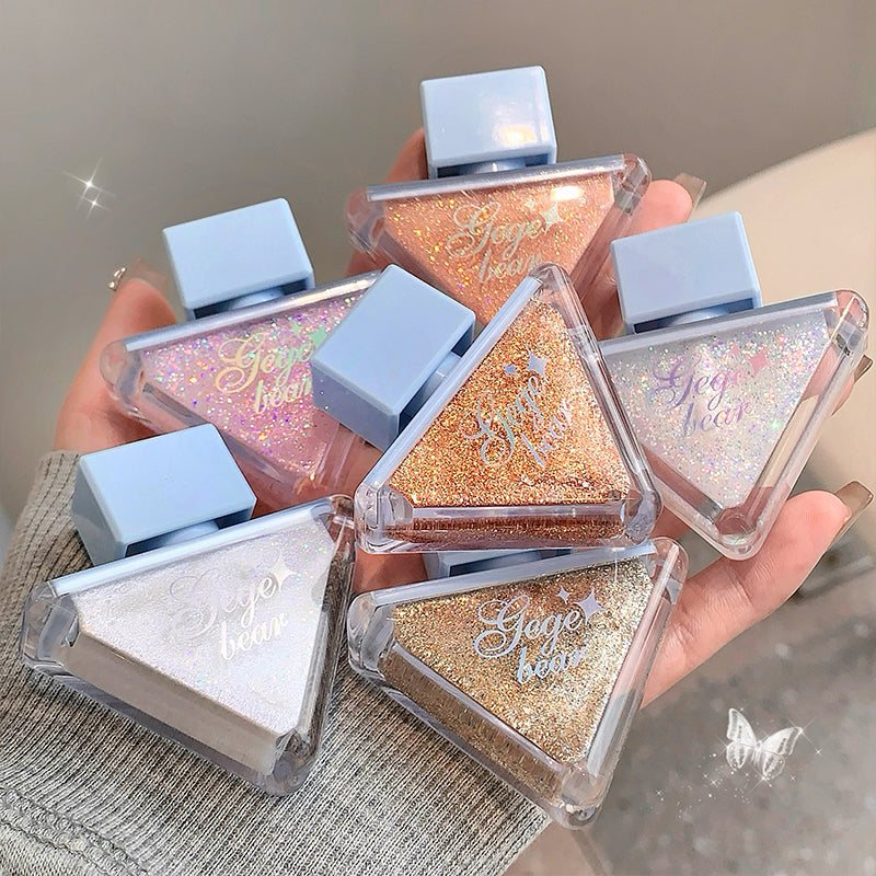 Hand holding multiple small rectangular containers with glittery contents and 'Gige bear' branding.