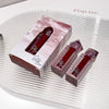 Red lip gloss with packaging on a textured white surface, branded 'Gege bear'.