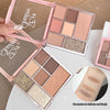 Makeup palette with various shades of eyeshadows and a hand holding it.