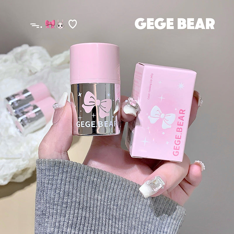 Hand holding a pink 'GEGE BEAR' product with packaging against a neutral background