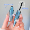Blue mascara with silver cap held by a hand against a gray background