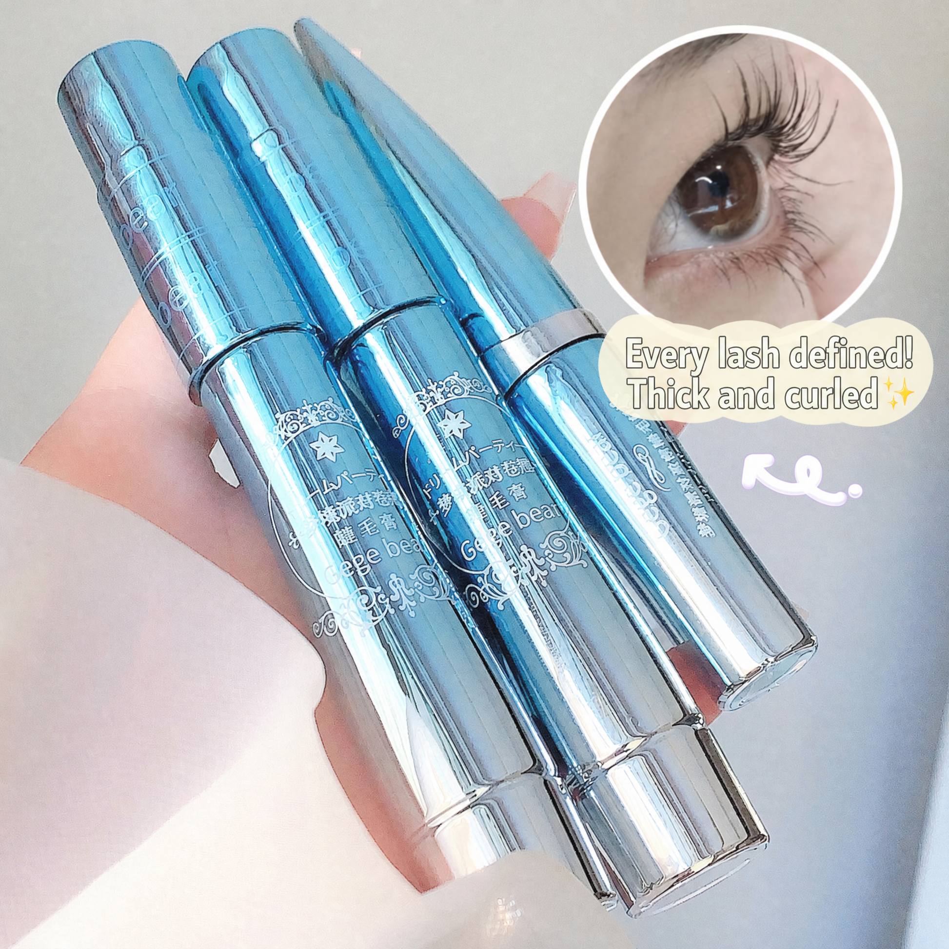 Two silver eyelash extensions with a close-up of an eye wearing them on a light background.