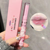 Pink lip balm with cartoon design held by a hand, close-up of lips with lip balm applied.