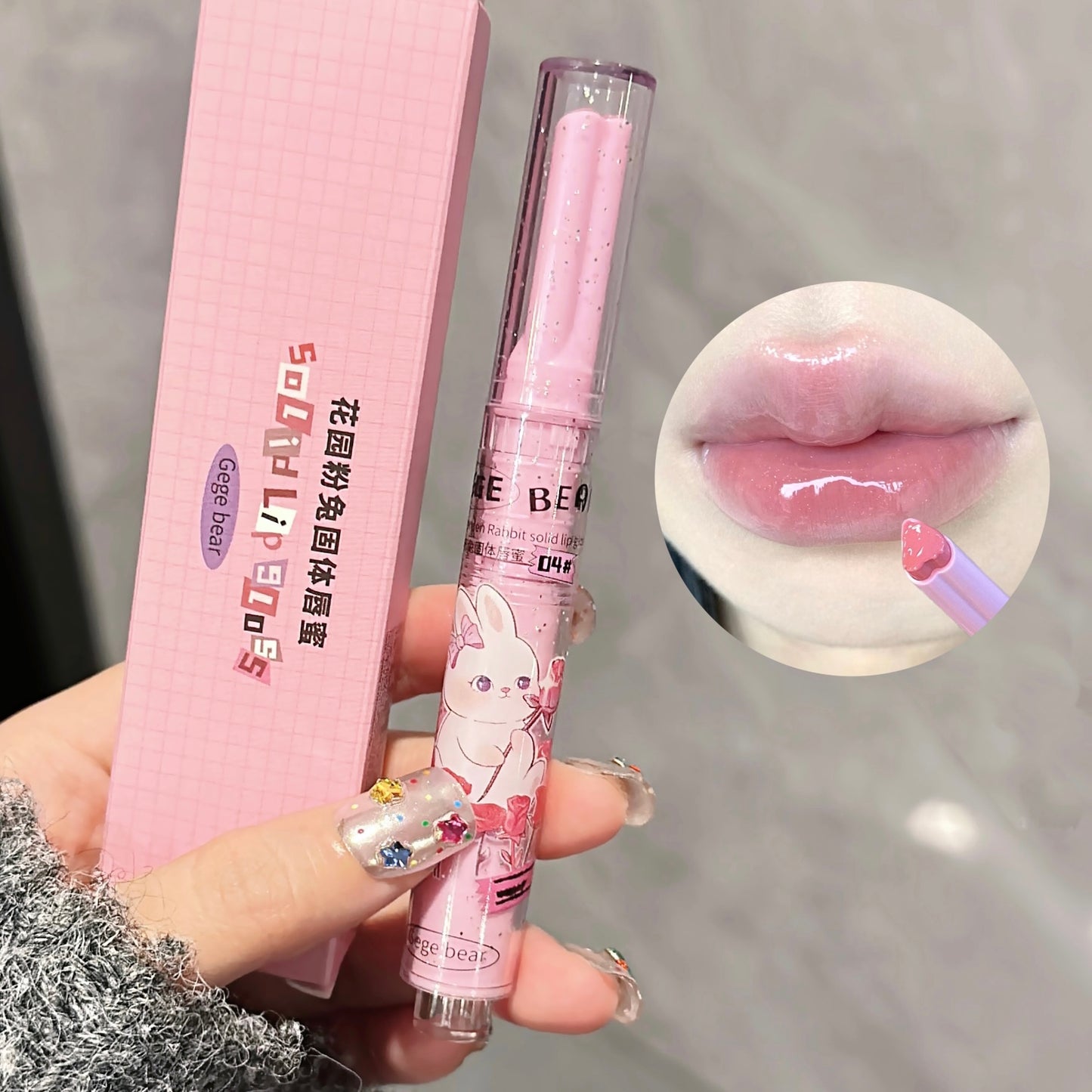 Pink lip balm with cartoon design held by a hand, close-up of lips with lip balm applied.