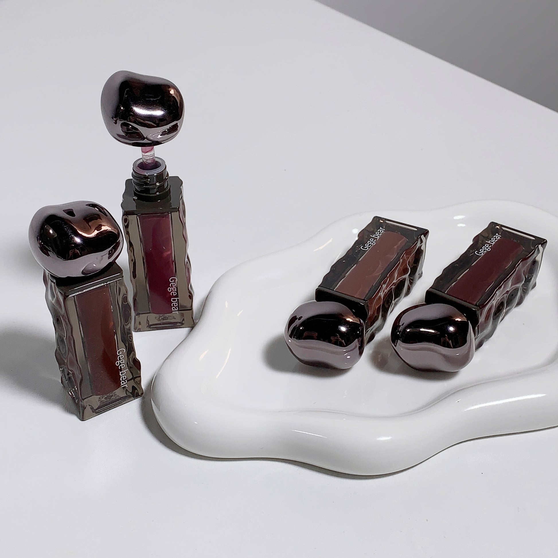 Lip gloss with metallic cap on a white surface