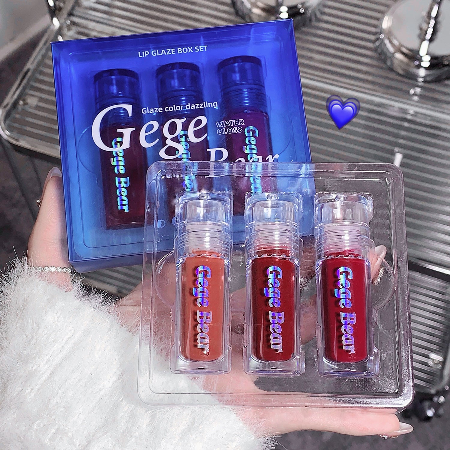 Gege Bear lip gloss set with packaging held by a person