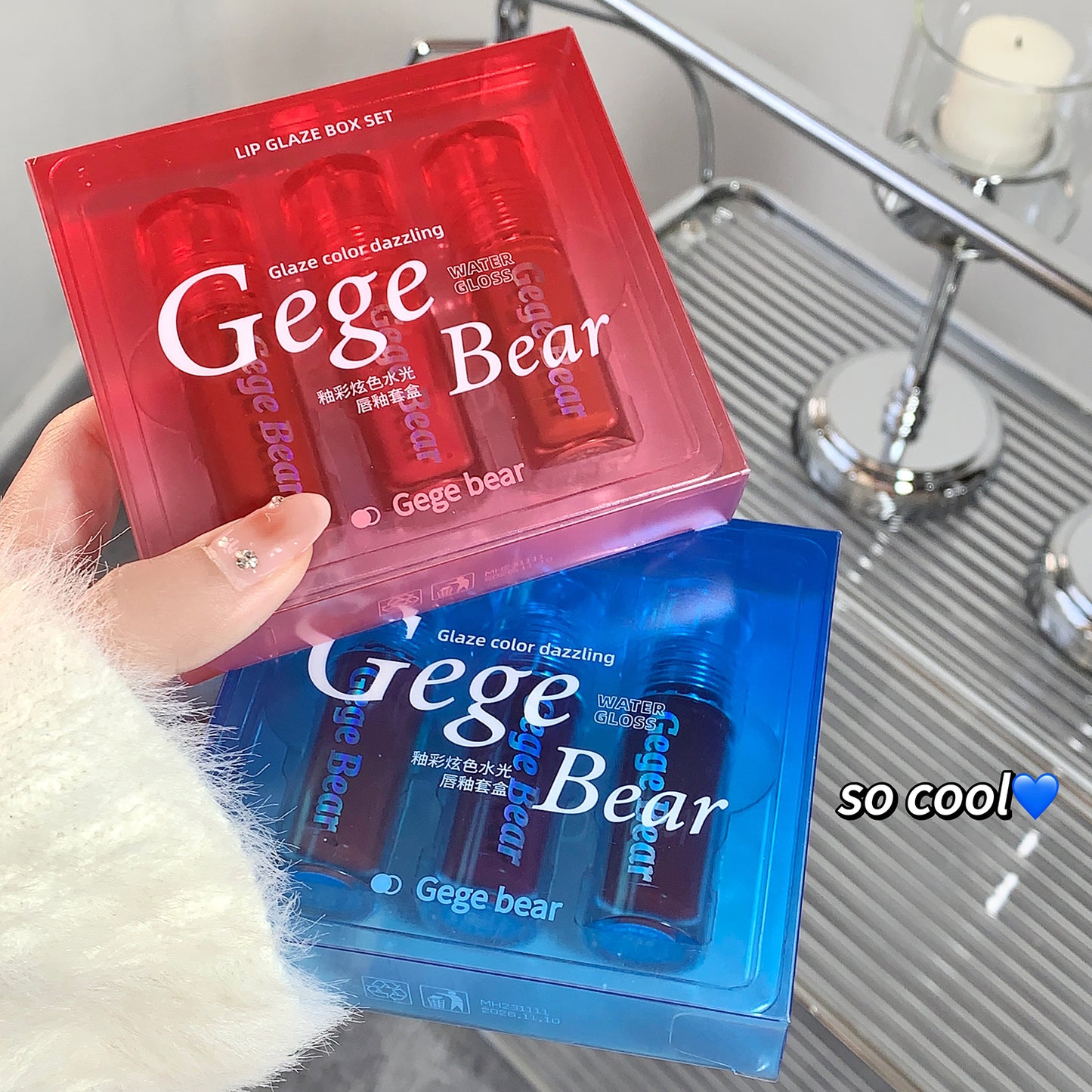 Red and blue Gege Bear lip gloss packaging held by a hand.