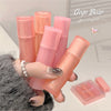 Hand holding pink lip balm tubes with 'Gege Bear' branding in the background