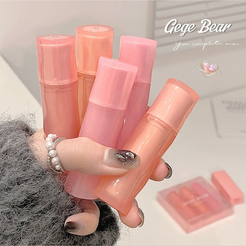 Hand holding pink lip balm tubes with 'Gege Bear' branding in the background