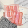 Set of pink skincare products with 'GEBEA' branding held by a person.