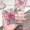 Makeup palette with pink and gold design held by a hand, with a blurred background.