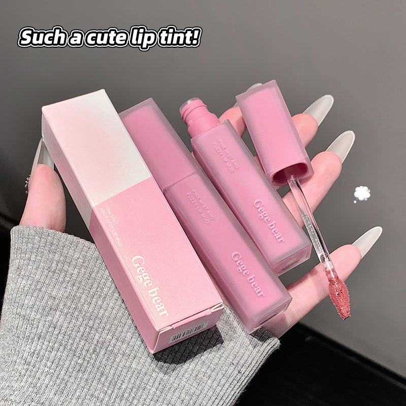 Pink lip gloss set with packaging held by a hand on a dark background