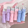 Set of colorful lip balms with bow decorations held in a hand.