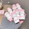 Hand holding multiple small white bottles with pink caps, featuring the brand 'Cige-line'.