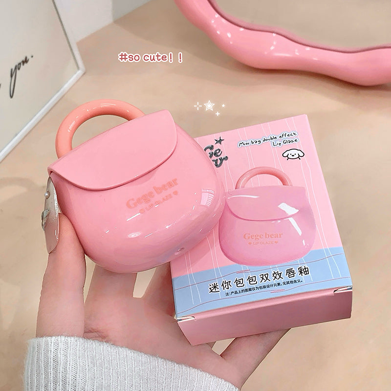 Pink lip gloss case held by a hand with packaging in the background