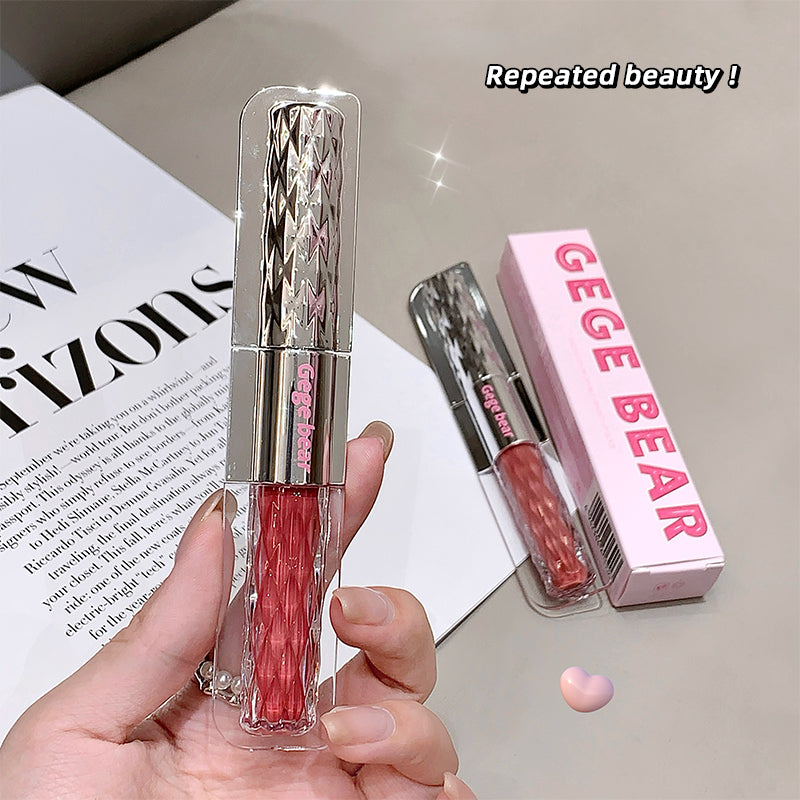 Lip gloss with pink shade held by a hand, next to its packaging labeled 'GEGE BEAR' on a magazine background.