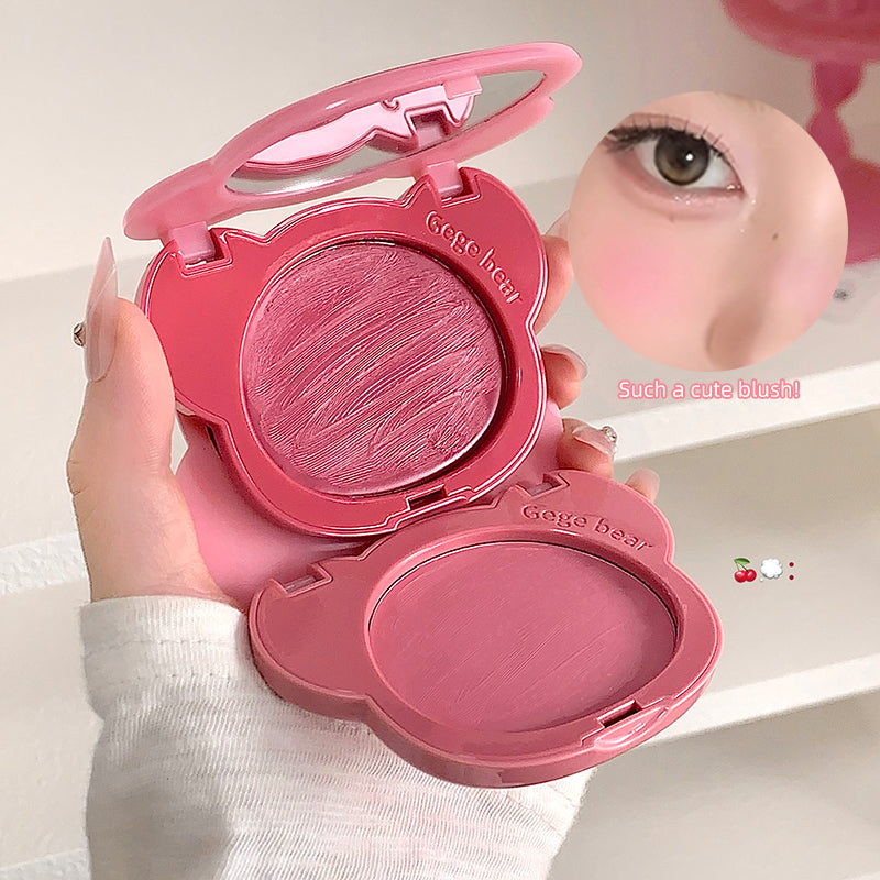 Pink blush compact with 'Geege bear' branding, held by a hand, with a close-up of applied blush on skin.