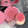 Pink makeup compact with a sponge applicator on a blurred background