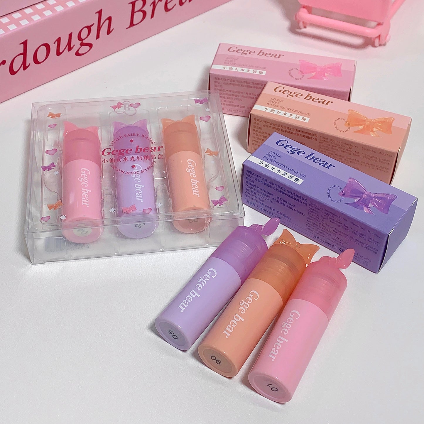 Set of Gege bear lip balms in pink, purple, and orange packaging on a white background.