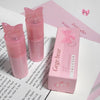 Pink lip gloss with butterfly design and packaging on a white surface.
