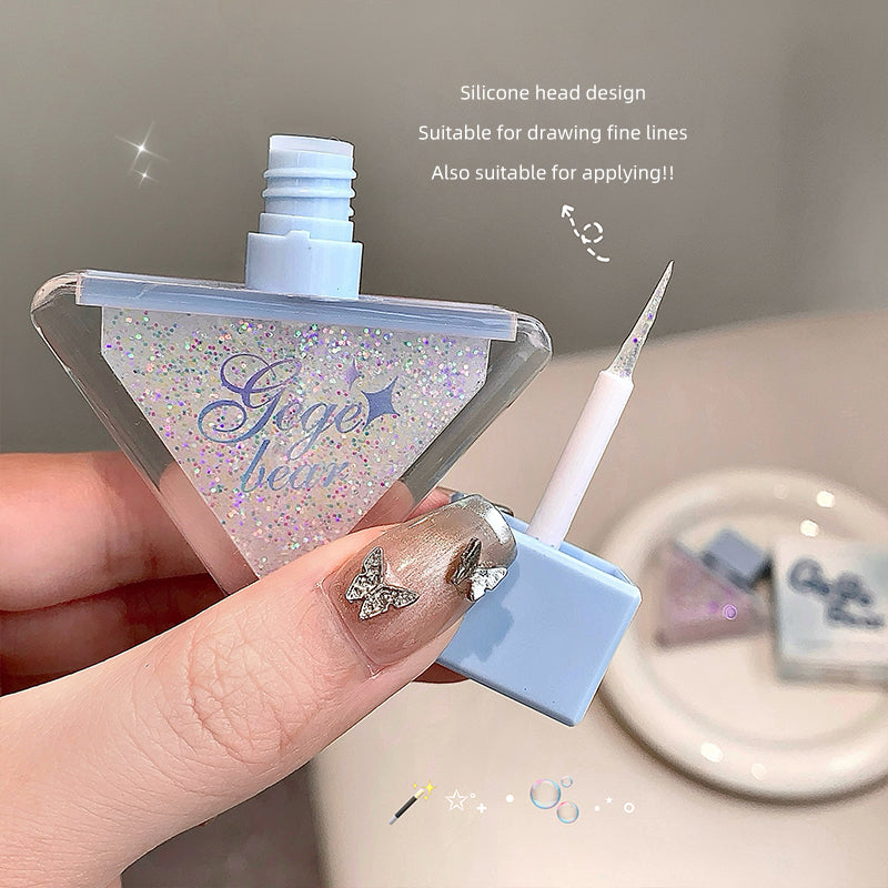 Small applicator with silicone head design, suitable for drawing fine lines, held by a hand.