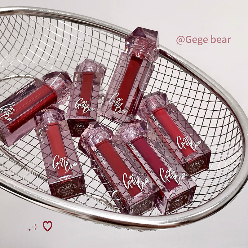 Red lip glosses with 'Gege Bear' branding in a metal basket