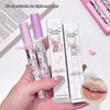 Lip gloss with bear design packaging held by a hand, on a light background.