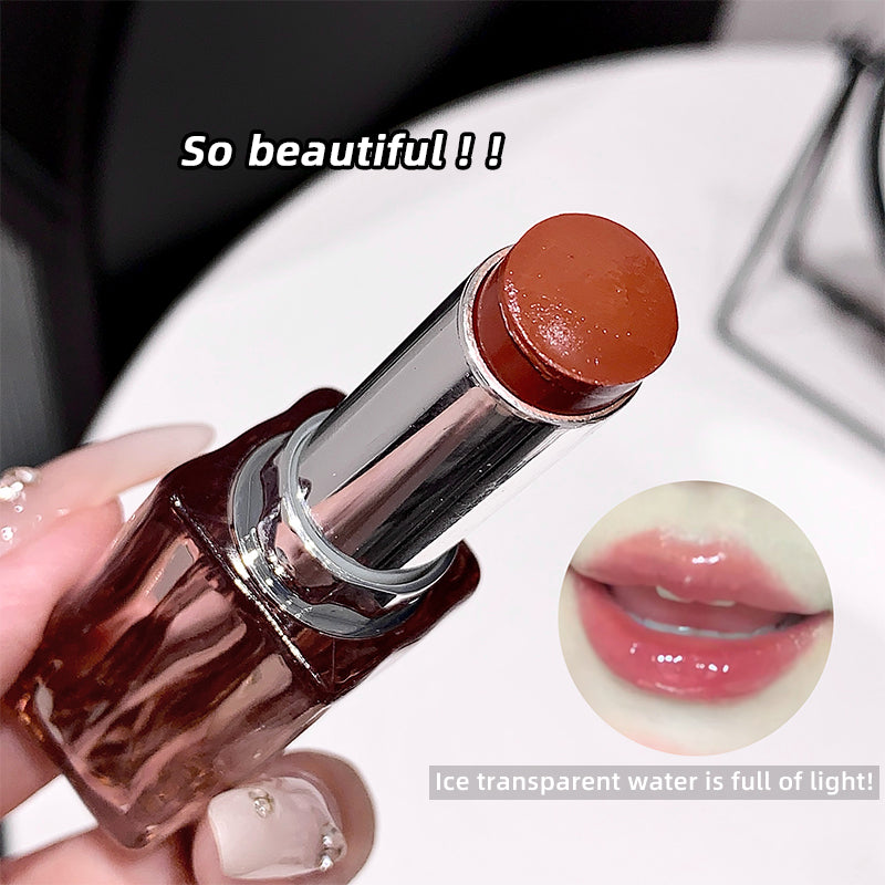Lipstick with a brown cap held by a hand, close-up view.