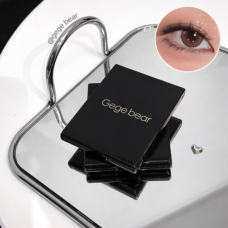 Stack of black makeup products with 'Gege bear' branding on a clear stand.