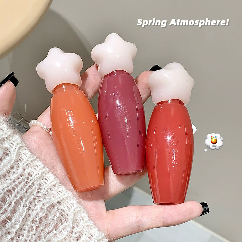 Three small bottles with star-shaped caps held in a hand, labeled 'Spring Atmosphere'.
