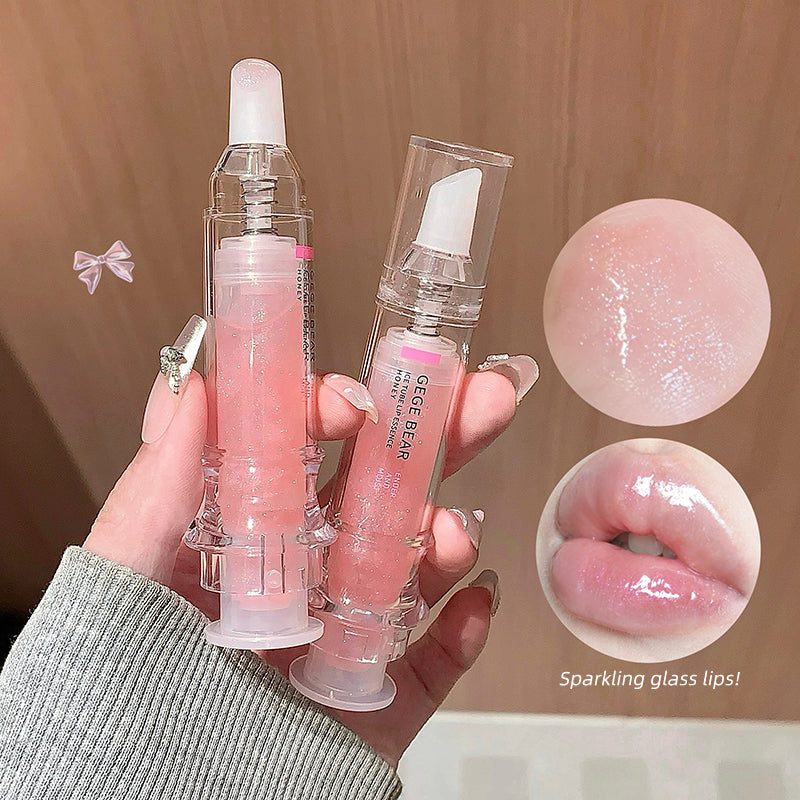 Hand holding a transparent lip gloss with pink liquid, showing close-up details on a beige background.