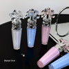 Set of lip glosses with decorative caps on a black surface.