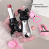 Lipstick-shaped keychain with bear design held by a hand, with text overlay.