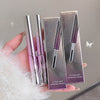 Two silver and purple mascara tubes with their packaging held by a hand against a neutral background.