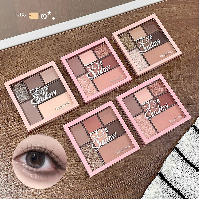 Five eye shadow palettes with a close-up of an eye wearing makeup on a wooden surface.