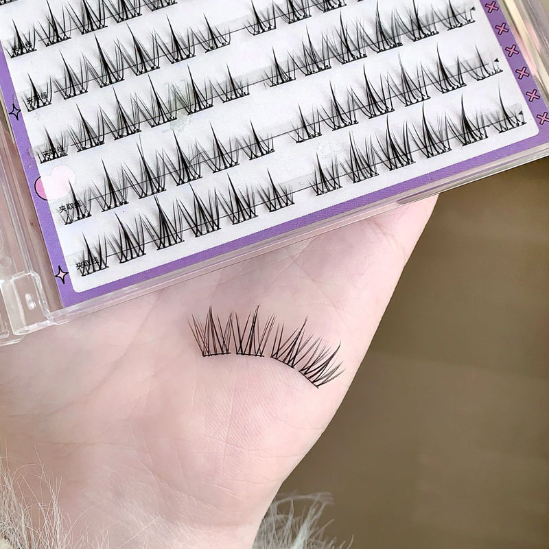 False eyelashes on a hand with packaging in the background