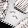 Eyelash extensions in clear containers with labels on a white surface