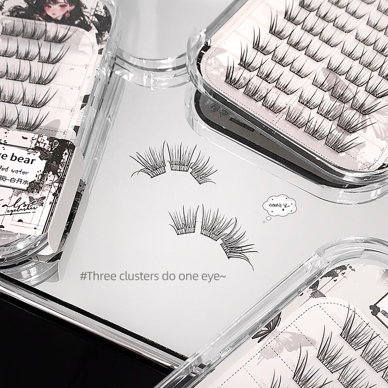 Eyelash extensions in clear containers with labels on a white surface